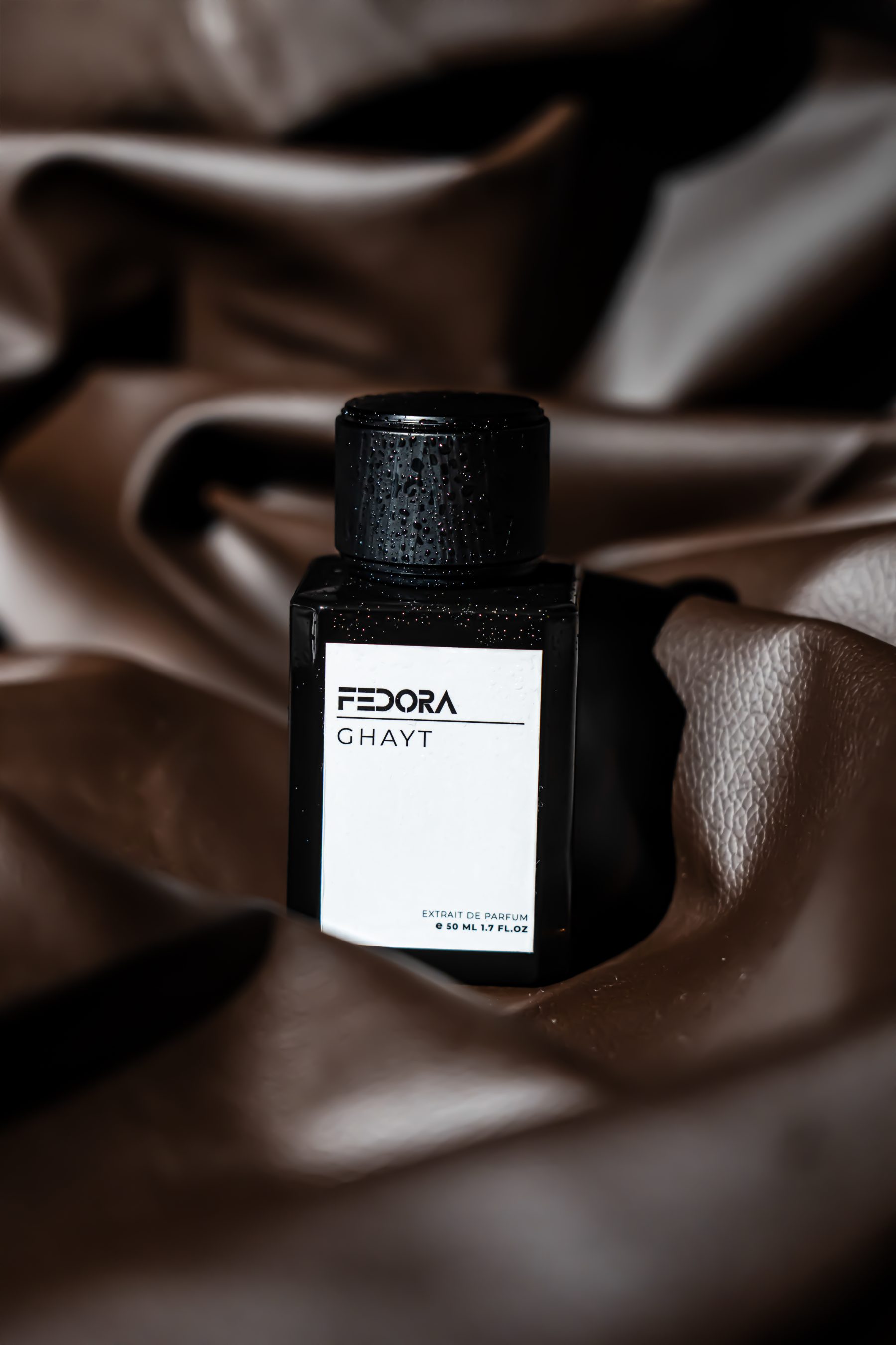 Fedora perfume bottle on leather